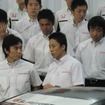 フォトセッションの合間に佐藤琢磨（最前列左）と談笑する伊沢拓也。