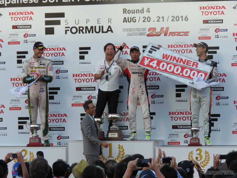 賞金ボードを手にガッツポーズの関口。星野監督やライバル選手たちも笑顔。