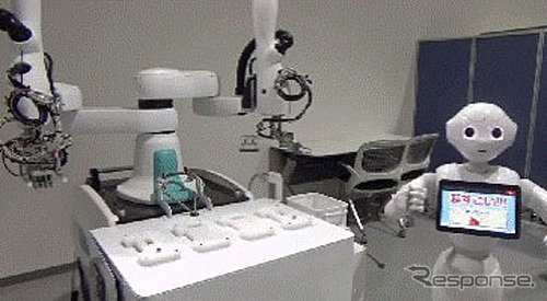 人から「Pepper」への指示で「duAro」がスマートフォンに液晶保護フィルムを貼るデモンストレーション