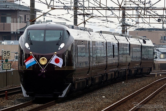 亀有駅を通過していくお召し列車。ルクセルブルクと日本の国旗が掲げられ、中央には菊の御紋が輝く。