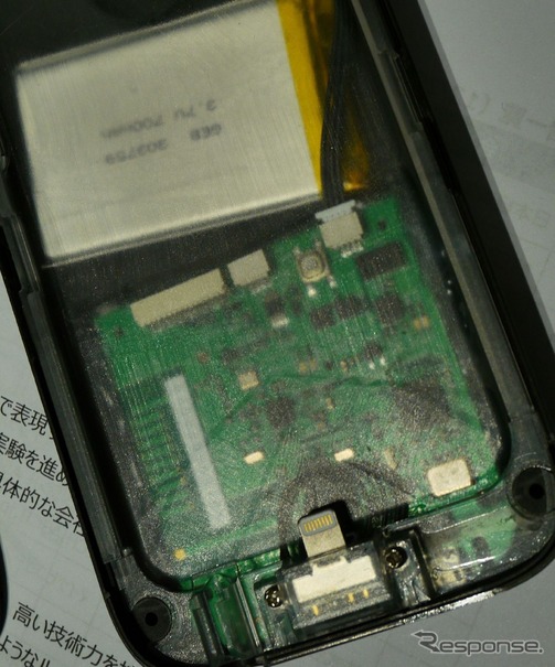 スマートフォンケースの内側に、スマートフォンと接続するプラグが見える。上部に見える白い部品はバッテリー。スマートフォンケース側のUSBから、スマートフォン本体と同時に充電する仕組み。