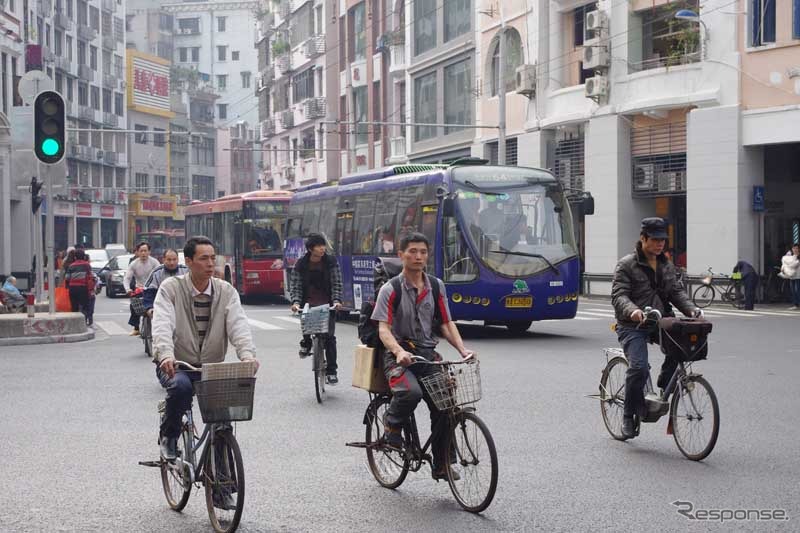 バス、自転車、そして多くの日本車が入り乱れる市街地