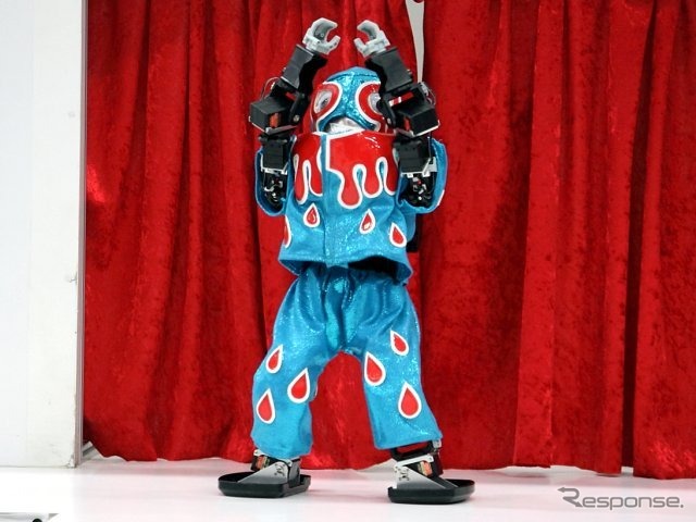 草加ロボットプロレスリングの代名詞的な存在で、ヘナチョコ・ロボット・アーティストの「流血仮面（ブルー）」。イヤらしい腰振りダンスをよく披露する下品キャラ
