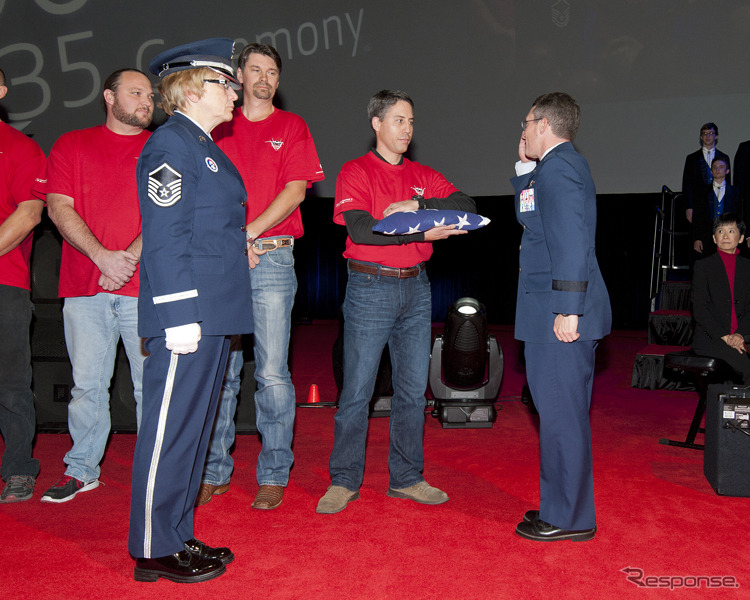 祝典で記念の国旗を受け取る米軍のマイケル・ロステイン准将