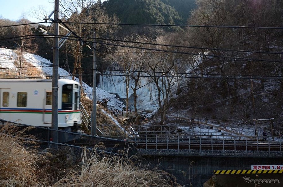 「あしがくぼの氷柱」（奥）が見える西武秩父線の芦ヶ久保～横瀬間。2月9日まで一部の列車が氷柱付近で速度を落として運転する。