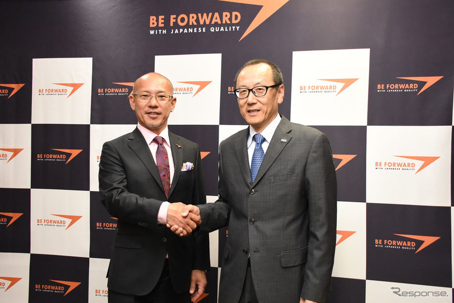 握手するビッグウェーブの服部厚司社長(右)とビィ・フォアードの山川博功社長(左)