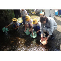 NOKグループ北茨城地区3社、大北川のアユ稚魚放流体験活動に参画　地元小学生とアユ稚魚30kgを放流し、北茨城市の環境保全を支援